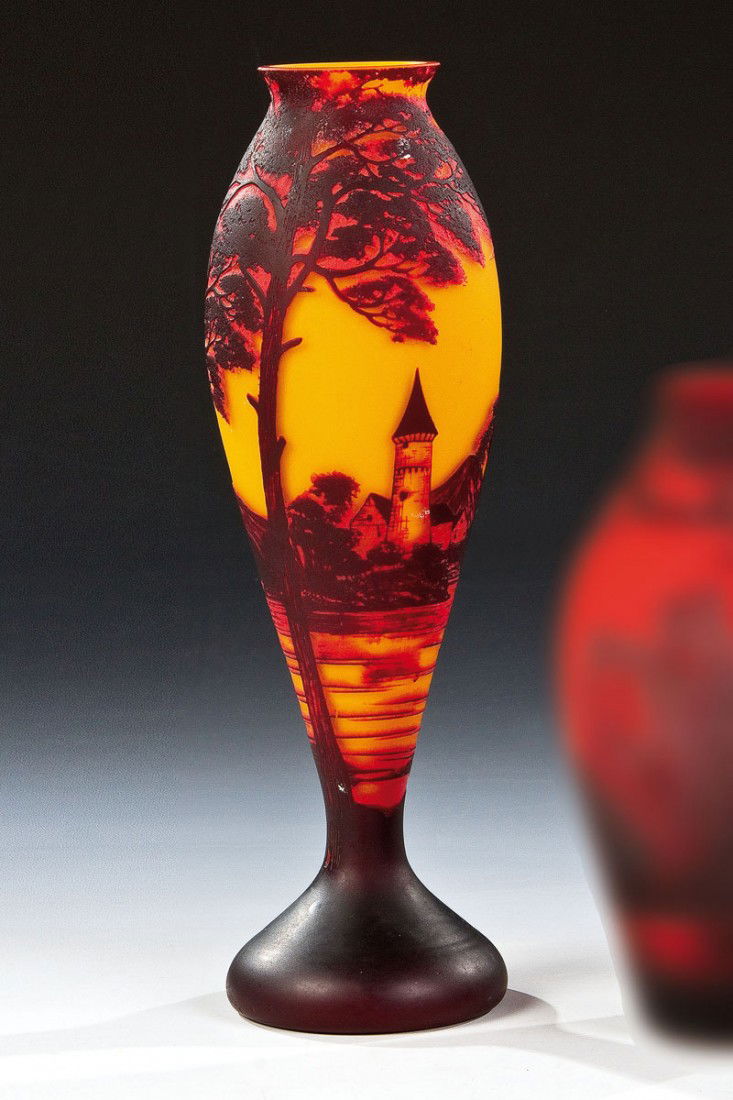 Vase: Vase Loetz Wwe., Klostermühle, um 1925 Farbloses Glas, innen opak gelb unterfangen, außen rot und schwarzviolett überfangen. Reliefiert geätzter Dekor: Flußlandschaft mit Baum- und Architektursta