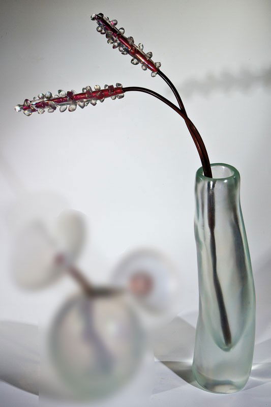 Vase ''Fuochi d'aqua': Vase ''Fuochi d'aqua' Giorgio Vigna (Entwurf), Venini, Murano 2002 Farbloses, dickwandiges Glas, matt irisiert. Zwei Kupferstäbe mit farblosen floralen Appliken. In Vibrogravur bez.: venini 2002 Gior