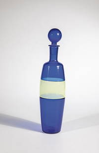 Bottle with stopper ''Incalmo: Paolo Venini (design), Venini, Murano, 1959 Colorless glass, cobalt blue underlay, with yellow 'mezza filigrana' band, fused in 'incalmo' technique. Original label of the manufactory. H. 35 cm Lit.: