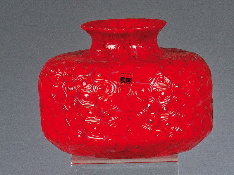 Vase ''A Spirale'': Vase ''A Spirale'' Ermanno Toso (Entwurf), Fratelli Toso, Murano, um 1950-55 Farbloses Glas, mit eingeschmolzenen spiralförmigen Murrine in Rotorange und Weißopal. Orig.- Klebeetikett der Manufaktur