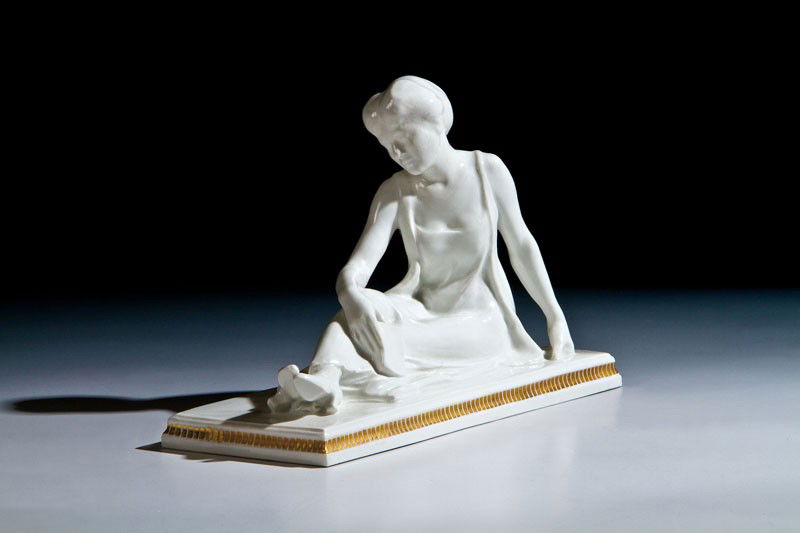 Modedame mit Buch: Modedame mit Buch KPM, Berlin, 1913 Auf Rechtecksockel mit Goldstaffage sitzende Dame, in der Rechten ein Buch haltend. Unterglasurblaue Zeptermarke. Reichsapfel- und Jubiläumsmarke ''1763 FR 1913''