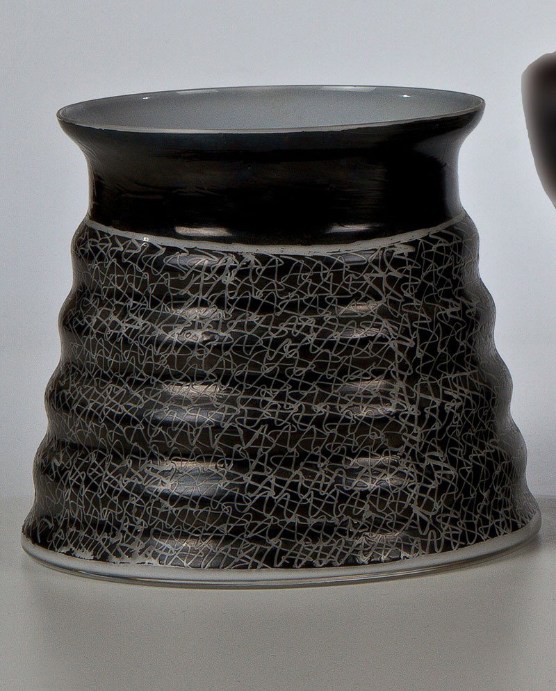 Vase: Vase Ivana Masitova, 1990 Farbloses Glas, innen mit weißem Opal unterfangen, mit schwarzer Flachfarbe flächig bemalt. Geritzter abstrakter Dekor. Bez.: MASITOVA 90 (in schwarzer Flachfarbe aufgemalt