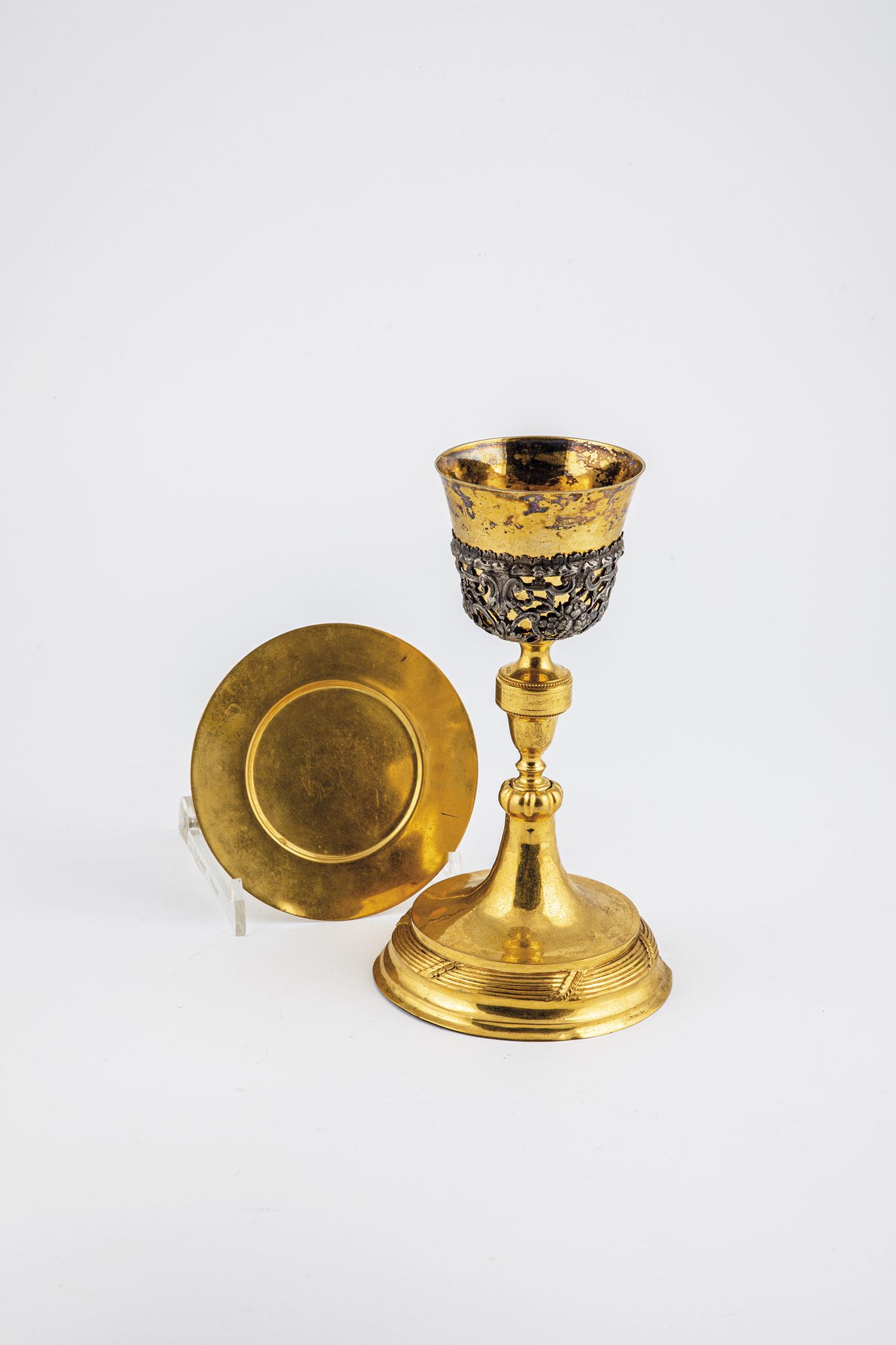 Chalice with host plate: Chalice with host plate 19th century metal, gilded. On round hollow base. Stem with pressed nodus. On the dome with applied openwork foliage and flowers. H. 24 cm. D. 14 cm.