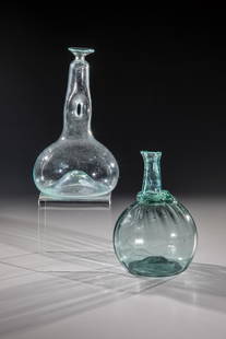 Two bottles: Two bottles partly Italy, 19th century. Blue-green, longitudinal optical glass with a high engraved back and tear, irregularly applied thread pad at the base of the neck. Pear-shaped bottle made of