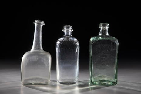 mixed lot of three bottles: Mixed lot of three bottles of 18th and 19th century, colourless or light green glass blown into model. Two rectangular in cross-section, one round with faceted cut ornaments on the shoulder. H. 16 to