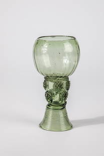 Roemer: Roman German, 17th century Light green glass with demolition. Spun base, open shaft with two rows of offset applied berry nubs. Underneath the longitudinally optically ribbed, bulbous cuppa, pinched