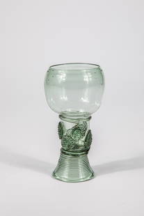 Roemer: Roman German, 17th century Green glass with demolition. Woven foot. Shaft open at the top with two rows of offset applied berry nubs. Thread pinched at the base of the compressed, bulbous cuppa. H. 11