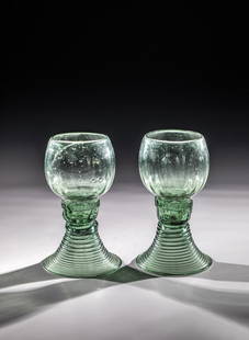 Pair of Roemers: Pair of Romans Germany, 1st half of the 19th century Green glass with demolition. Woven foot. Three berry nubs placed on each hollow shaft. At the base of the spherical, optically ribbed cuppa, pinche