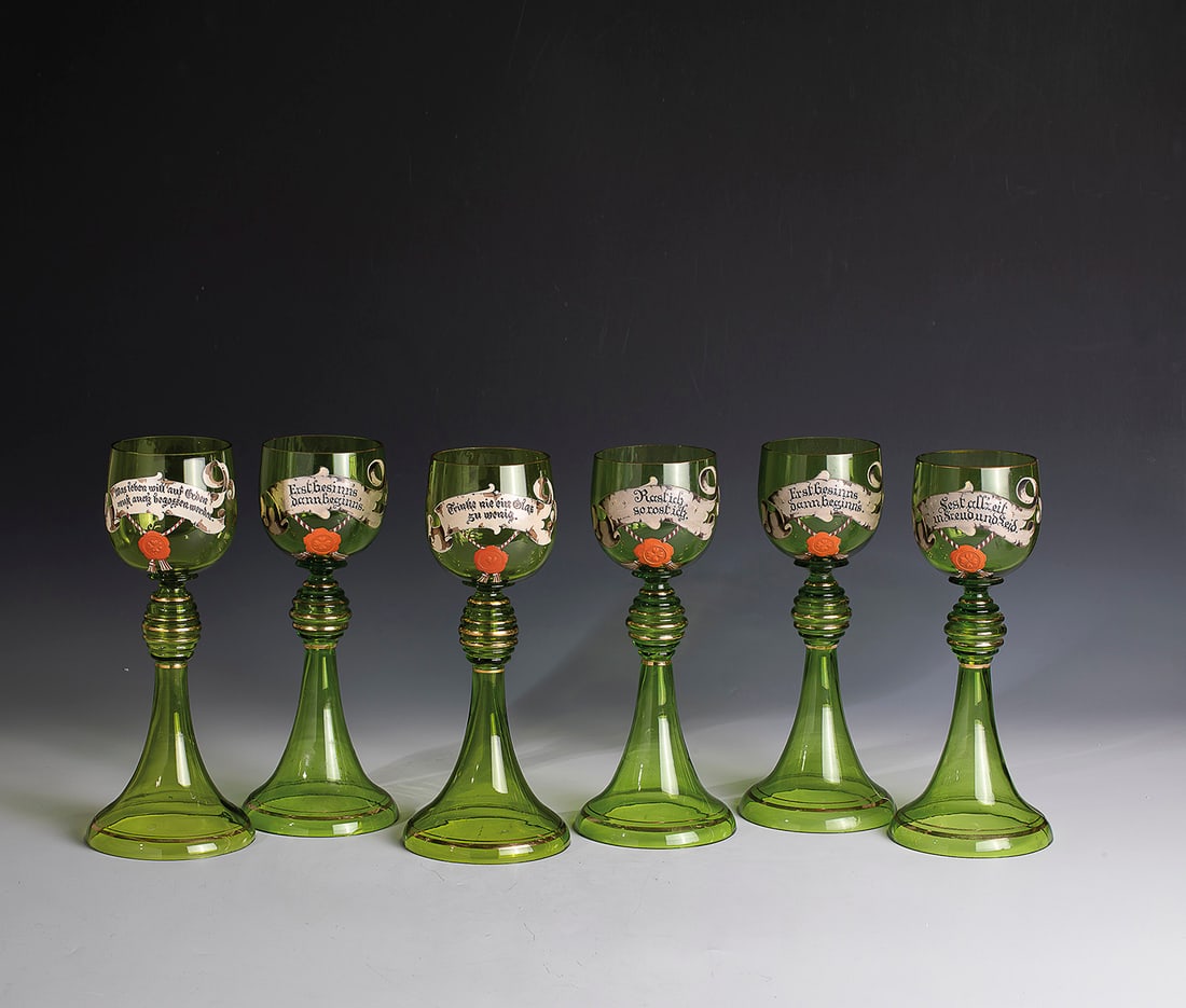 Set of six great Romans with toasts: Set of six great Romans with toasts Germany, circa 1880 Light green glass. Trumpet-shaped foot with ribbed, partly gilded nodus. On the spherical Kuppa Scherpe with red seal and toast: "Never drink a