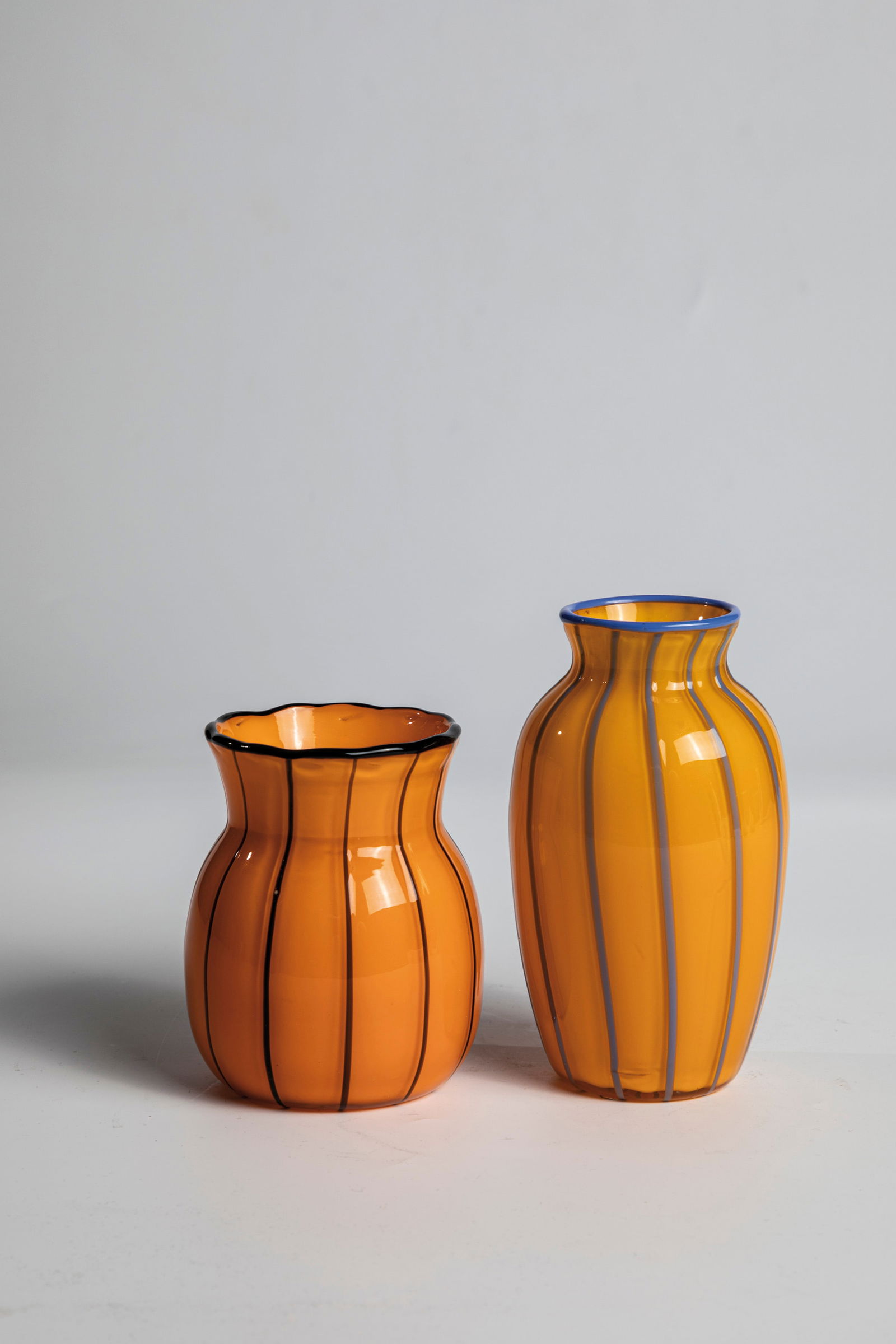 Two Small Vases ''Version 157'': Two small vases ''Version 157'' Loetz Wwe., Klostermühle, 1914 Colourless glass with orange opal underlay. Vertically melted black-violet and light blue threads. The muzzle thread also applied in bla