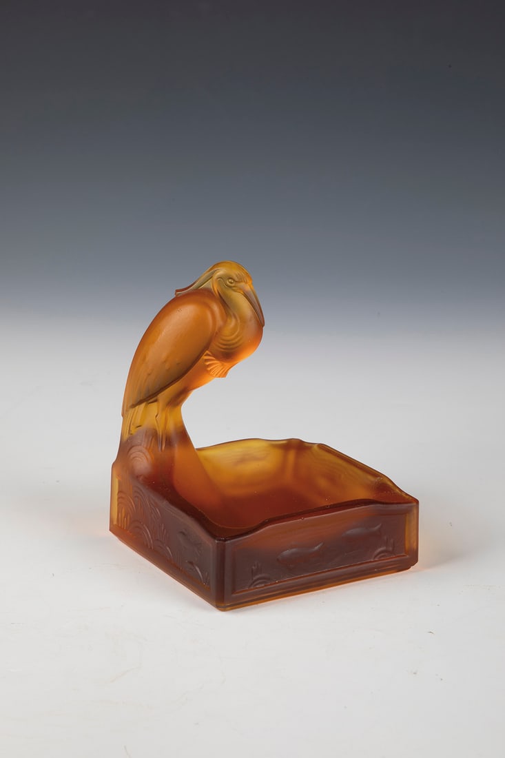 Ashtray: Ash bowl Cristalleries de Val Saint-Lambert, 20th century Amber glass, pressed into the mold. On one corner a high-seated heron. On the ground inscribed: ''VAL ST LAMBERT BELGIQUE'' (pressed up). H. 1