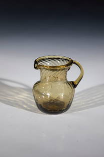 Creamer: Cream jug England, 18th century Olive-coloured glass with tear-off. Compressed, obliquely blown wall with folded lip edge. Appliquéd handle. H. 7 cm