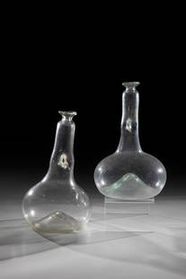 Two double-neck bottles: Two double-neck bottles Probably South German, 17th century Colourless glass with tear-off. Lofty ground. Bulbous wall. Compressed in the middle at the base of the tube neck. Pulled in below the