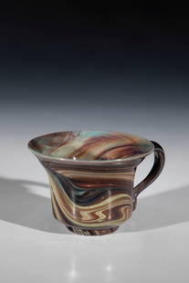Cup made of agate glass: Cup made of agate glass Murano, probably Lorenzo Radi, around 1850 So-called agate glass with marbling in brown and khaki tones. Slightly raised floor with tear-off. Handle applied to the protruding