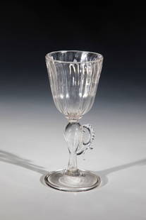 Wing glass: Casement glass Liège, Façon de Venise, E. 17th century Colourless, slightly greyish tinted glass. Disc base with the edge folded downwards. Baluster shaft with pinched wing appliqué.