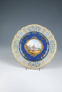 View plate: View plate Meissen, 2nd half of the 19th century Deeply hollowed, round plate on a standing ring. In the mirror, on a royal blue background, gold ornaments and floral gold-etched rocaille reserve. In