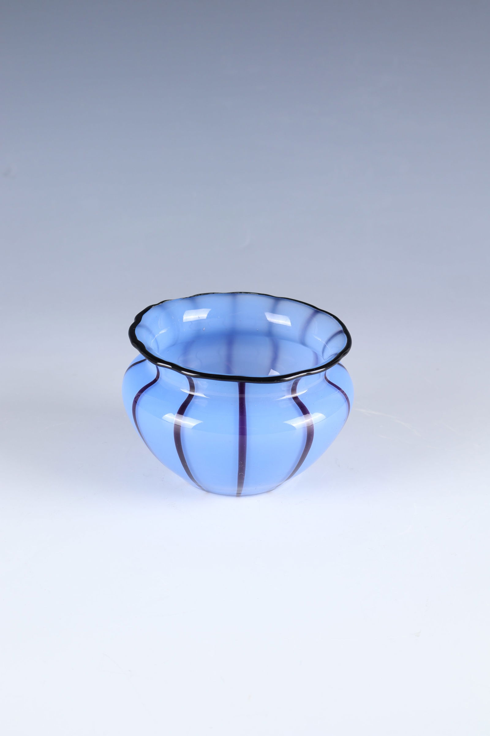Small bowl: Small bowl Loetz Wwe., Klostermühle, c. 1915 On light blue opal, colourless top layer with melted black-violet threads. The wavy muzzle edge with black-violet thread overlay. H. 7 cm.
