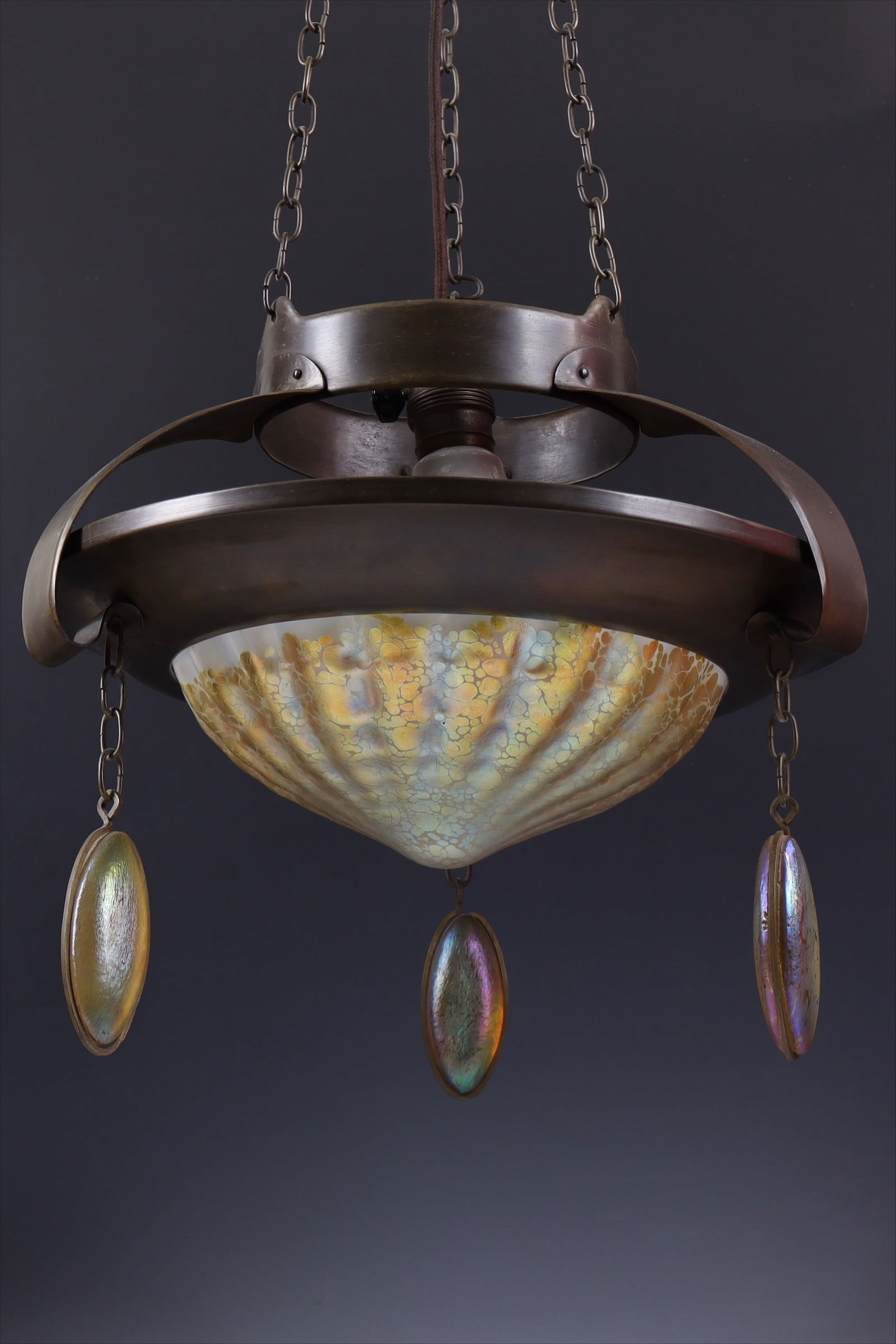 Important pendant lamp "Candia Papillon": Loetz Wwe., Klostermühle, 1904. Shade made of colorless, vertically optically ribbed glass with a whitish opal underlay. Irregularly rolled-in silver-yellow flakes. The three glass pendant elements a