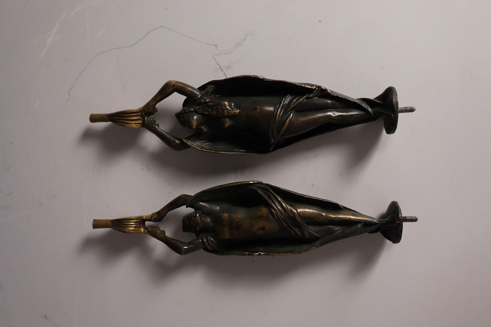 Two figurative candlestick parts: Two figurative candlestick parts Probably German, around 1900 candlestick parts. Fully sculptural depiction of two winged figures, holding a bellows in their hands. Brass, light patina. H. 18.5 cm.Zwe