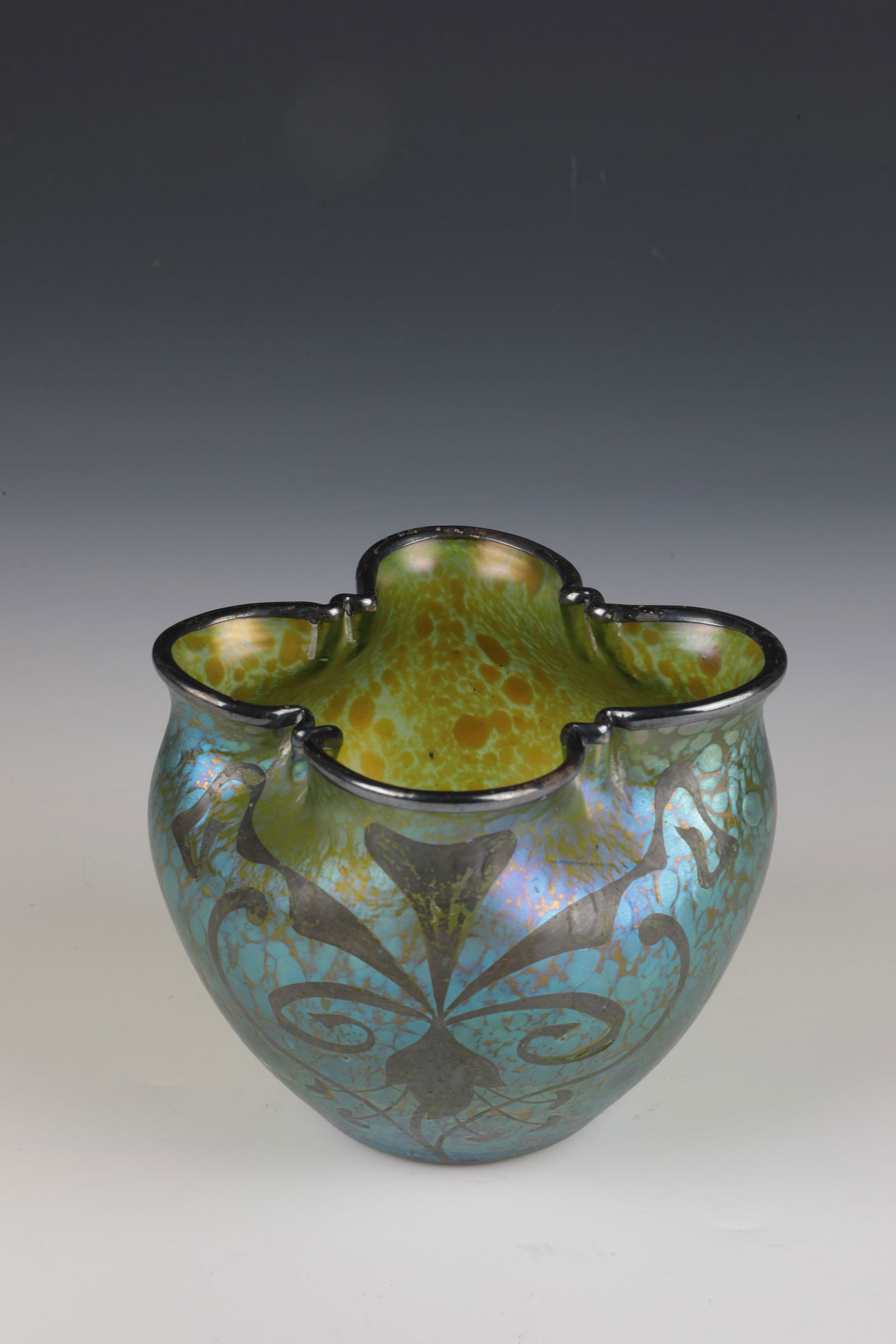 Vase ''Creta Papillon'' with silver plating: Vase ''Creta Papillon'' with silver plating Loetz Wwe., Klostermühle, c. 1900 Green glass with silver-yellow crumble melting. Matt iridescent. Quatrefoil muzzle rim with galvanic silver plating.