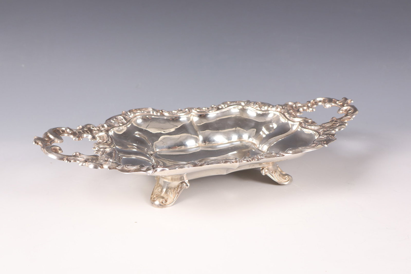 Shell: Bowl late 19th century silver. On four feet the deep shell body with vertical folds. The passable, profiled edge with flowers and shells. Two rocaille handles dents on the sides. Hallmarked on the edg