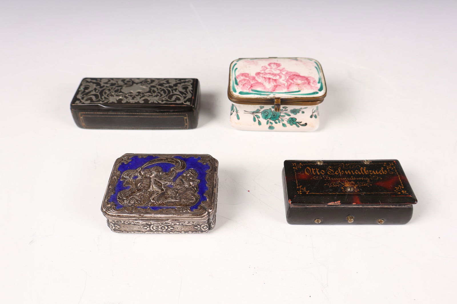 Bundle of four pill boxes: Mixed lot of four pill boxes 19th / 20th century Consisting of: ceramic with putto and floral decoration, silver with enamel and putto, two wooden boxes with silver inlays or gold decoration. L. 5.5 t