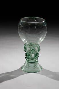 Roman: Roman German, 18th century Green glass with tear-off. Ribbed trumpet foot. Berry nubs applied to the shaft, which is open at the top. At the base of the oblique optically blown cuppa, circumferential