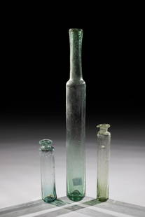 Three tube bottles: Three tubular bottles, 18th century. Light green, bubbled glass. Elongated wall with tubular neck and folded muzzle edge. H. 8.5 to 23.5 cm