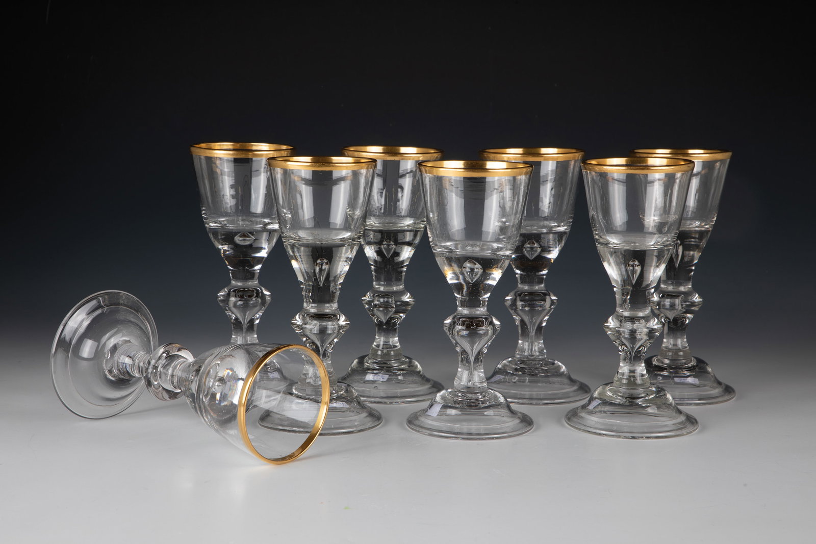 Eight trophies: Eight goblets Lauenstein, around 1770 Colourless glass with partly ground tears. Shell foot with folded edge downwards. Hollow baluster shaft. Air pearl pierced in the base of the cuppa. Gold-plated l