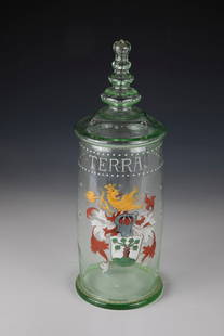 Lidded tankards: Lidded tankard German 19th century, light green glass. Compressed stance. Slightly bulbous wall with polychrome painted coat of arms. Above it inscription ''TERRA'' in white enamel. Lid with four-join