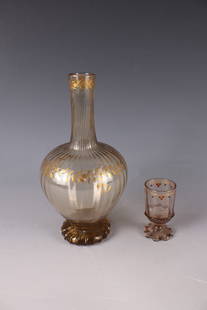 Bottle and small mug: Bottle and small mug Emile Gallé, Nancy, c. 1880/85 Smoky brown, longitudinal optical ribbed glass. Circumferential, stylized, ornamental decoration in polished gold and red opaque enamel: leaf or fr