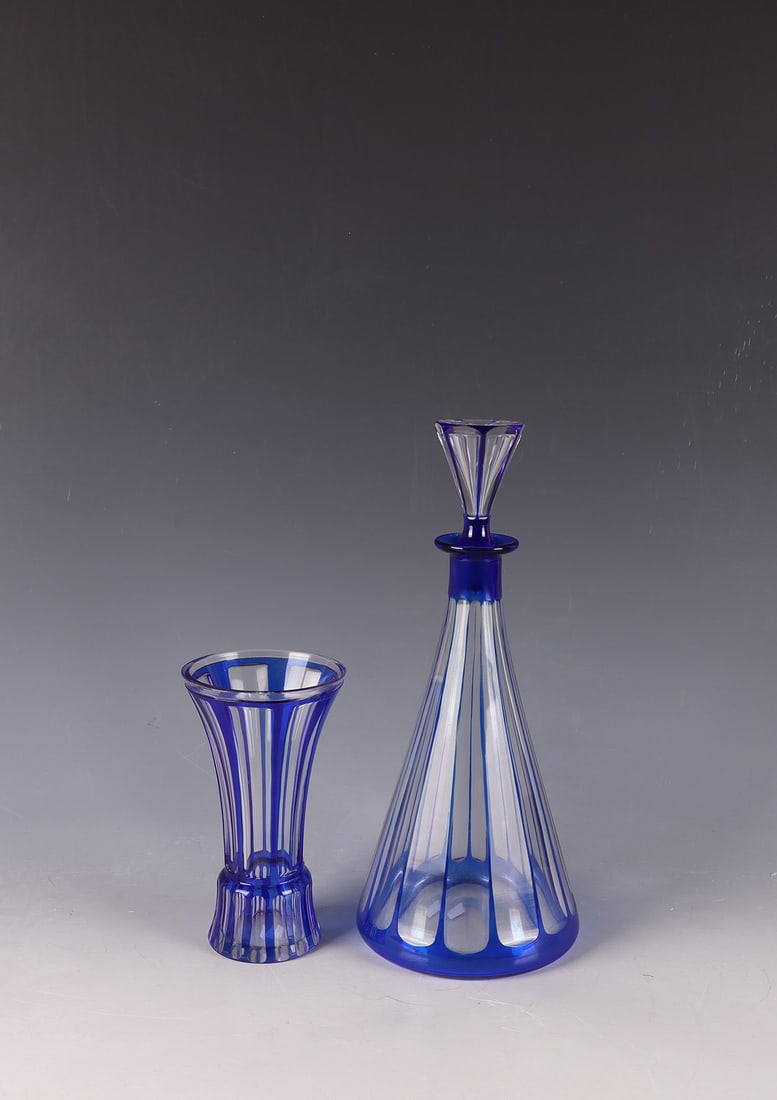 Bottle with stopper: Bottle with stopper Baccarat, around 1930 Colourless glass, blue overlay. Vertical, 13-fold peel grinding. Bottom inscribed: Etching stamp. H. 28.5 cm. In addition: beaker. Colourless glass, blue over