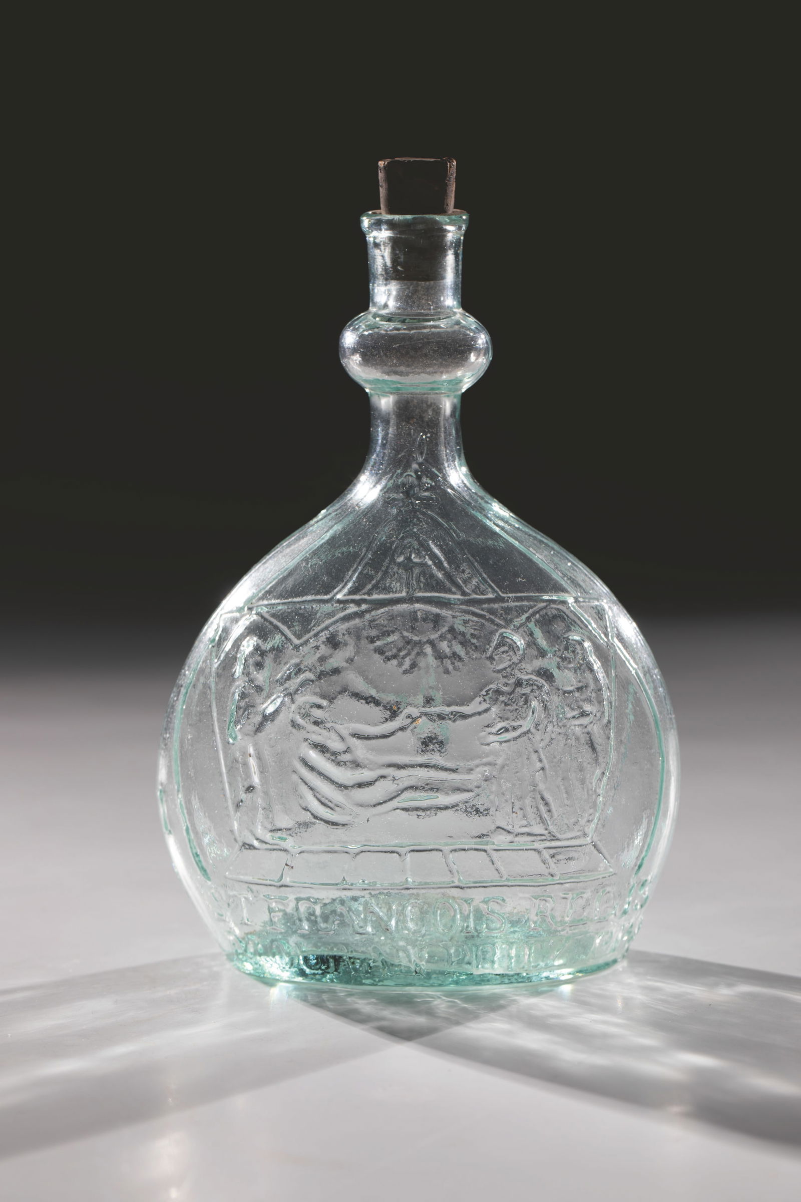 Pilgrim's bottle depicting Saint François Régis: Pilgrim's bottle depicting Saint François Régis, France, 19th century, light green pressed glass. On the wall, flattened on both sides, religious representations and inscriptions: ''ST. FRANCOIS REG