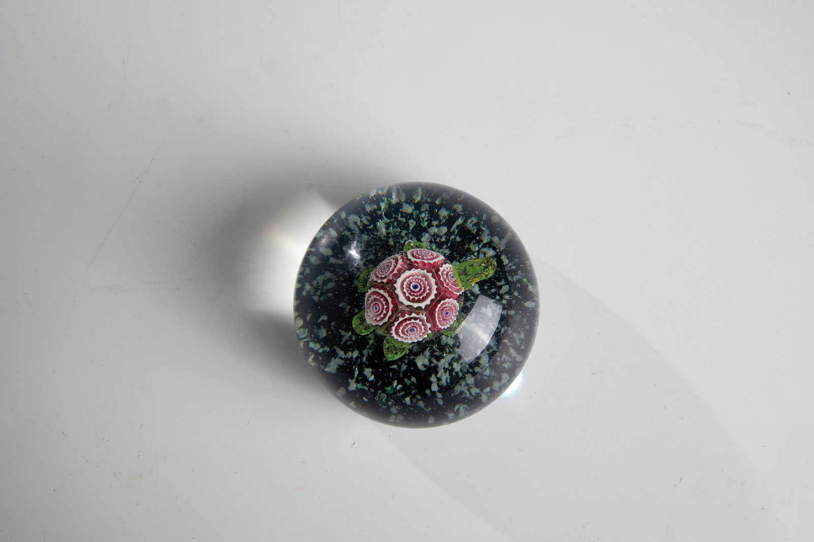 Paperweight: Paperweight China, 20th century. Plastic turtle with shell made of murrines on sapphire blue cushions with crumbs. D.8.0cm H.5.3cm.