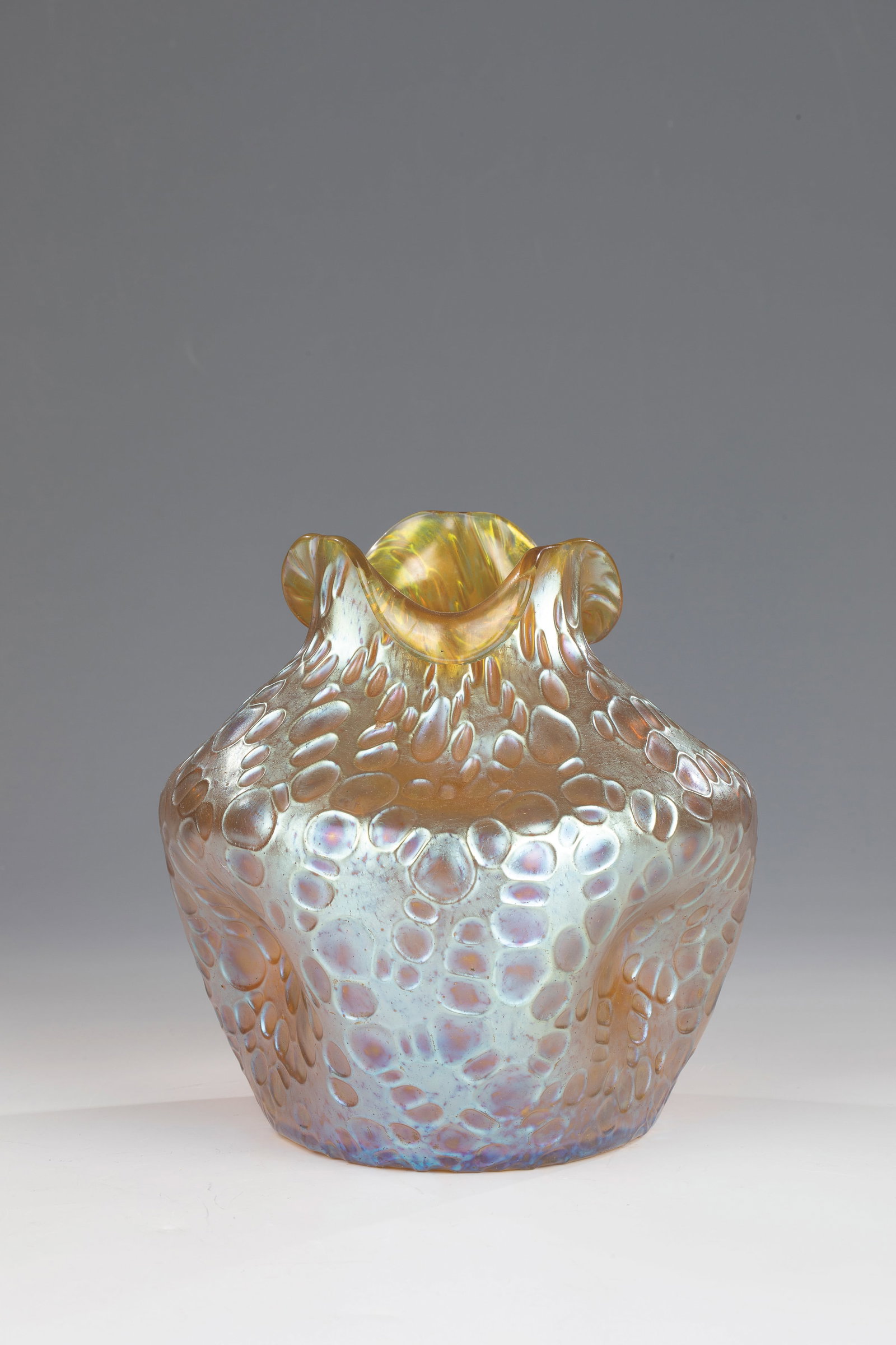 Vase ''Candia Diaspora'': Vase ''Candia Diaspora'' Loetz Wwe., Klostermühle, 1902 Colourless, spherically blown glass with silver-yellow powder melting. Iridescent. Wall pressed three times and lobed outwards accordingly. H.