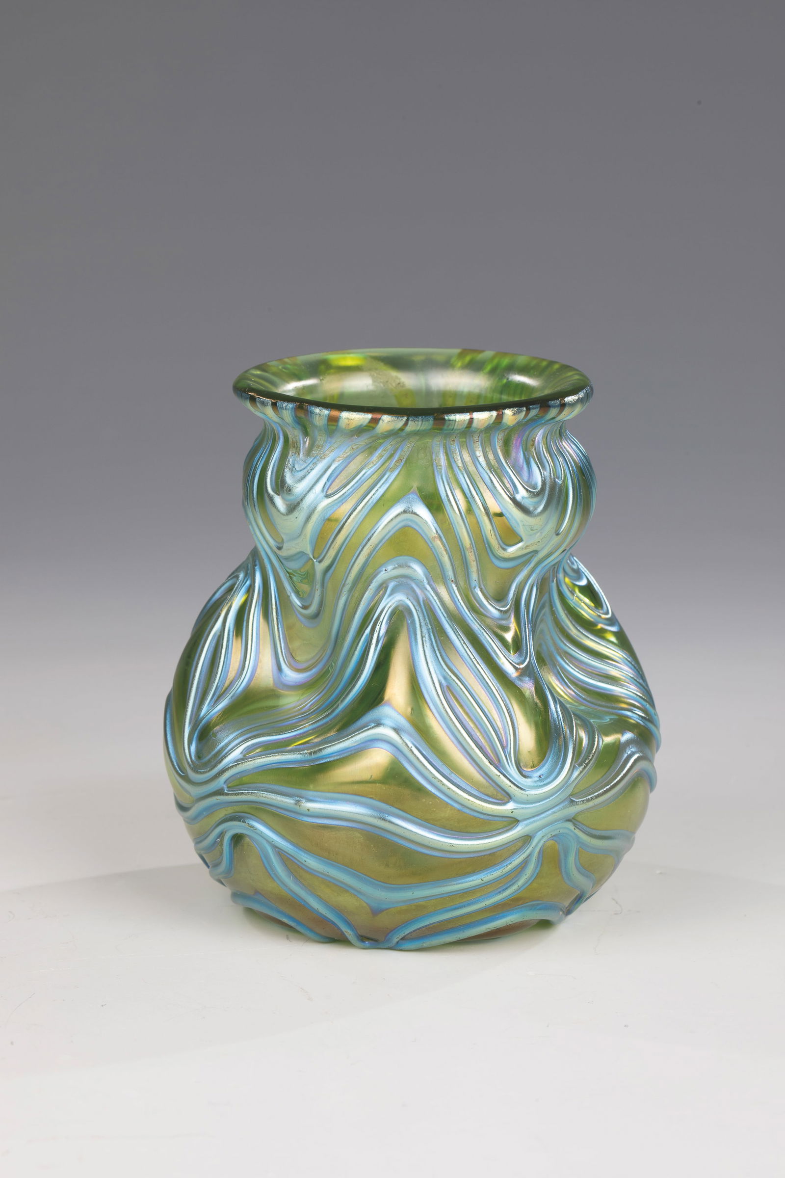 Vase ''creta Formosa'': Vase ''creta Formosa'' Loetz Wwe., Klostermühle, 1902 Green glass. In strong relief, spun thread decoration in silver-yellow, irregularly warped with the hook. Wall triple dented. Reduced and iridesc