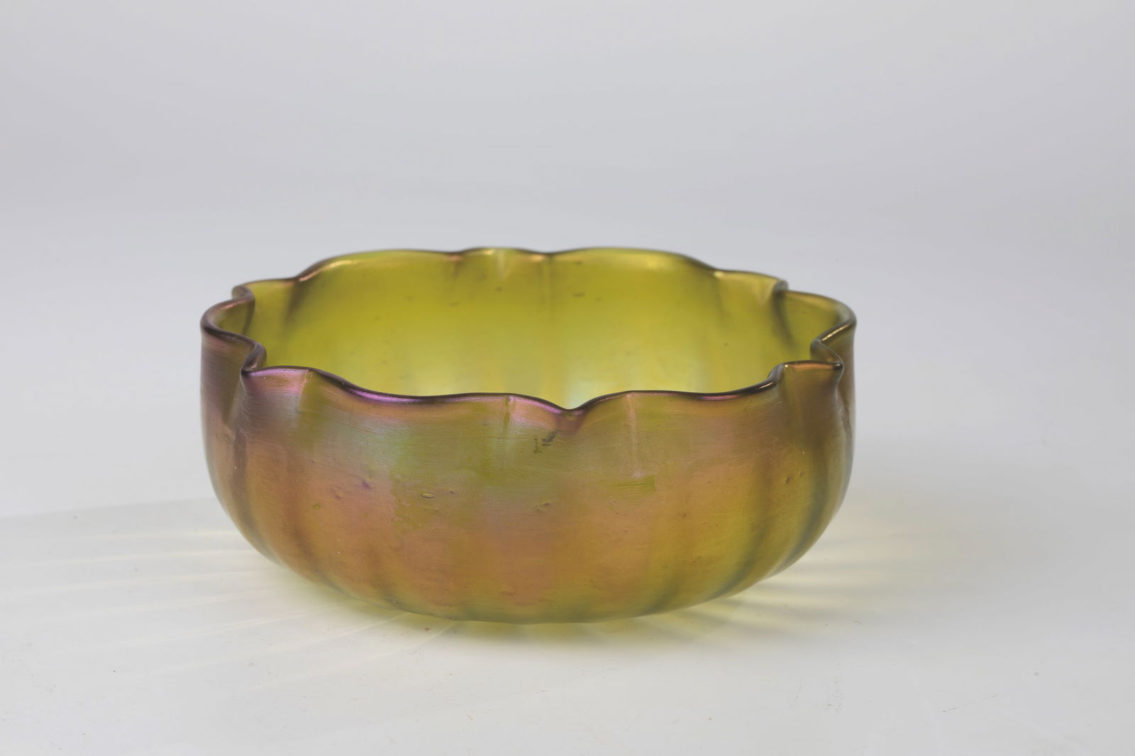 Shell: Bowl Loetz Wwe, Klostermühle, c. 1900 Colourless glass, greenish-bronze overlay. Wavy dented, pinched muzzle edge. Iridescent. H. 5 cm.