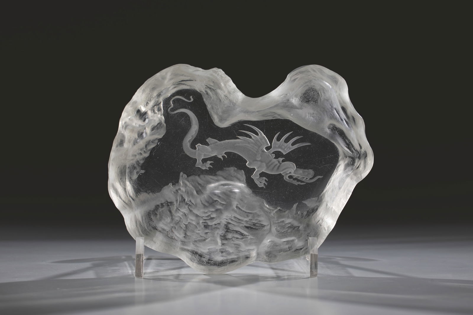 Shell: Bowl Heinrich Hoffmann (design), Gablonz an der Neiße, 1932-33 Colourless glass, pressed into the mould, matted and recut. In the ground a flying dragon in Chinese style. L. 16 cm. Lit.: P. Nový, In
