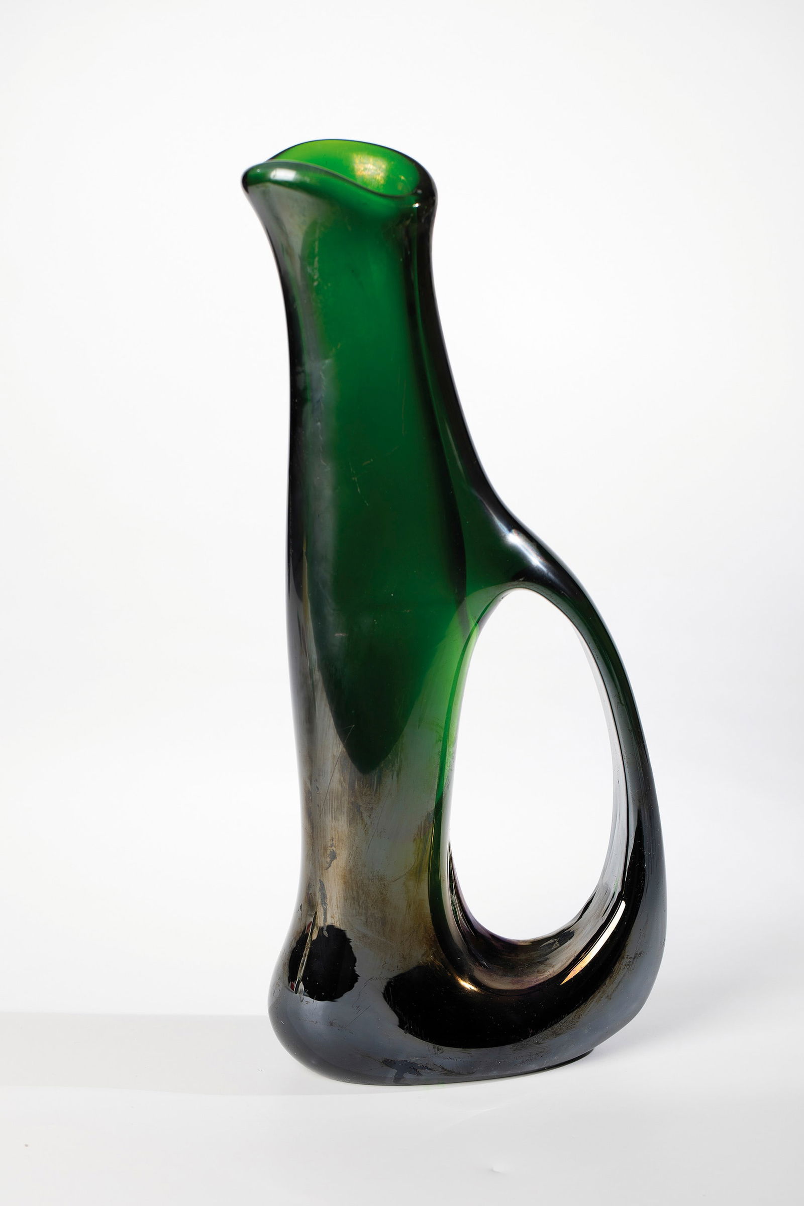 Vase ''anse volanti'': Vase ''anse volanti'' Giorgio Ferro (design), Arte Vetreria Muranese (A.Ve.M.), Murano, c. 1952 Emerald green glass, freely blown and shaped. Wide curved ribbon handle pulled out of the wall. strongly