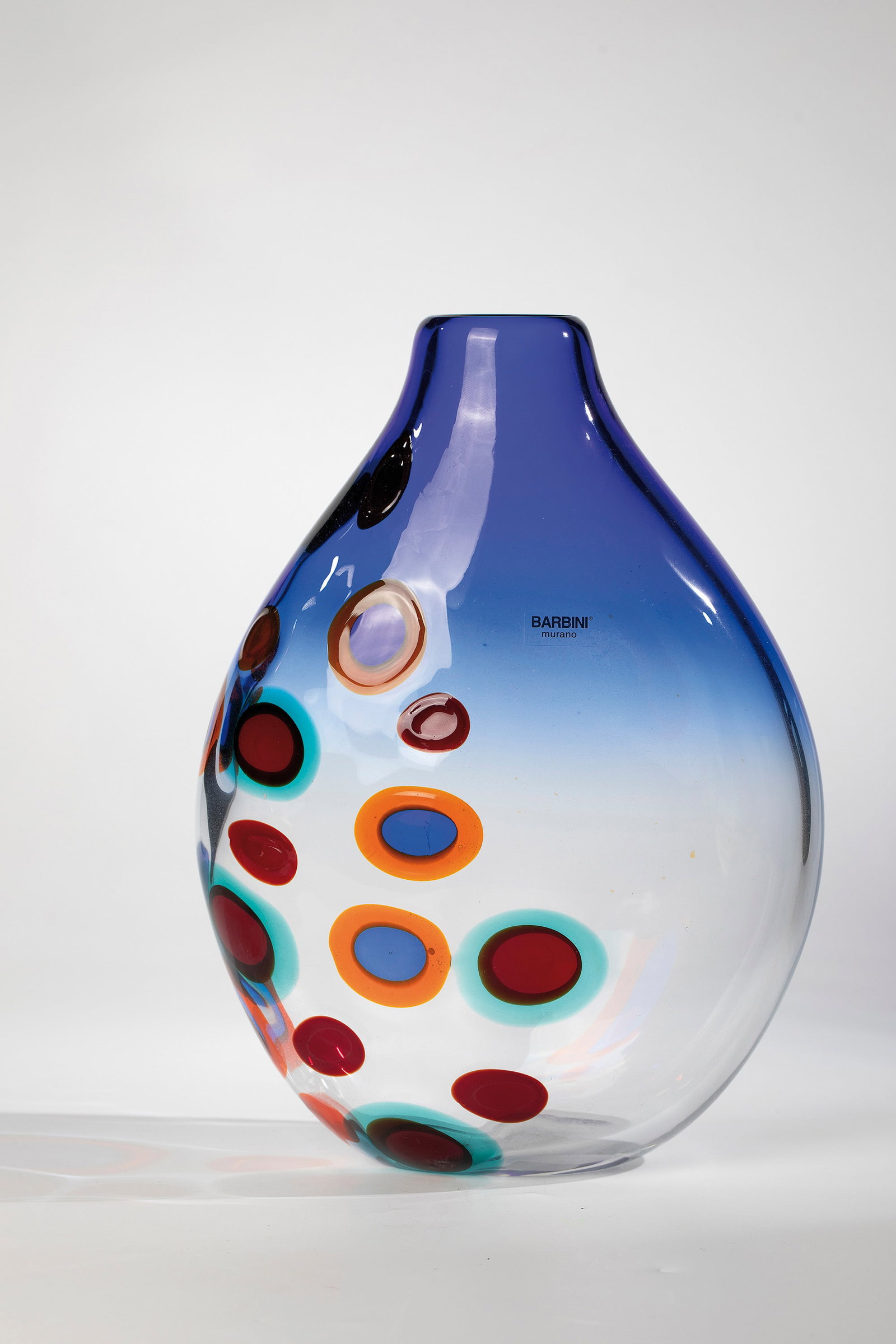 Vase: Vase Barbini, Murano, after 1980 Colourless, thick-walled glass with a partly blue gradient. The outer wall with melted ring murrine in the colours black-violet, orange, red, turquoise and blue. Origi