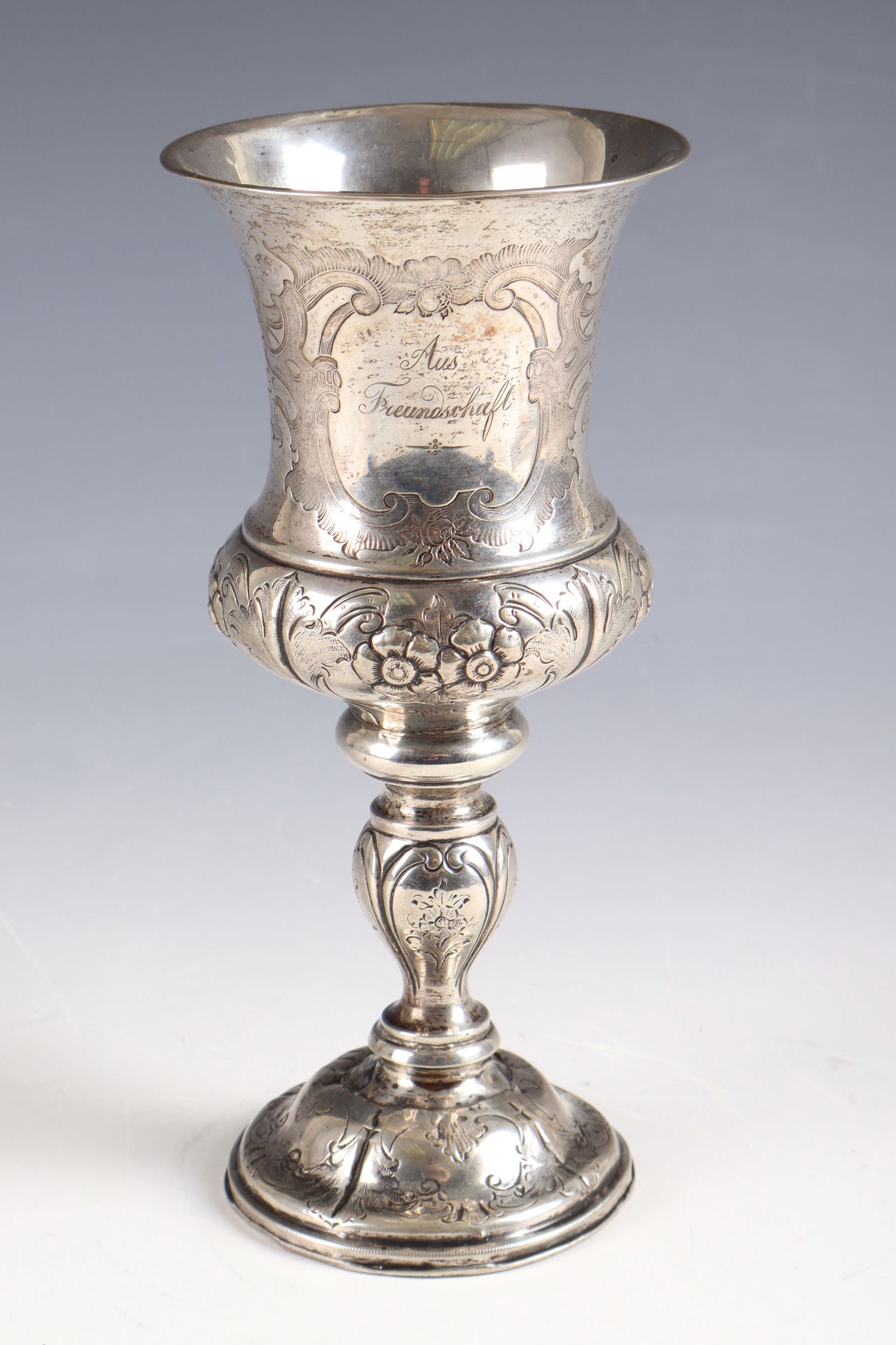 Goblet Cup: Goblet, dated 1858, silver. Small, round hollow base above it shaft with disc nodi and the goblet-shaped cuppa with flared edge. Extensively decorated with engraved and embossed flower and seed decora