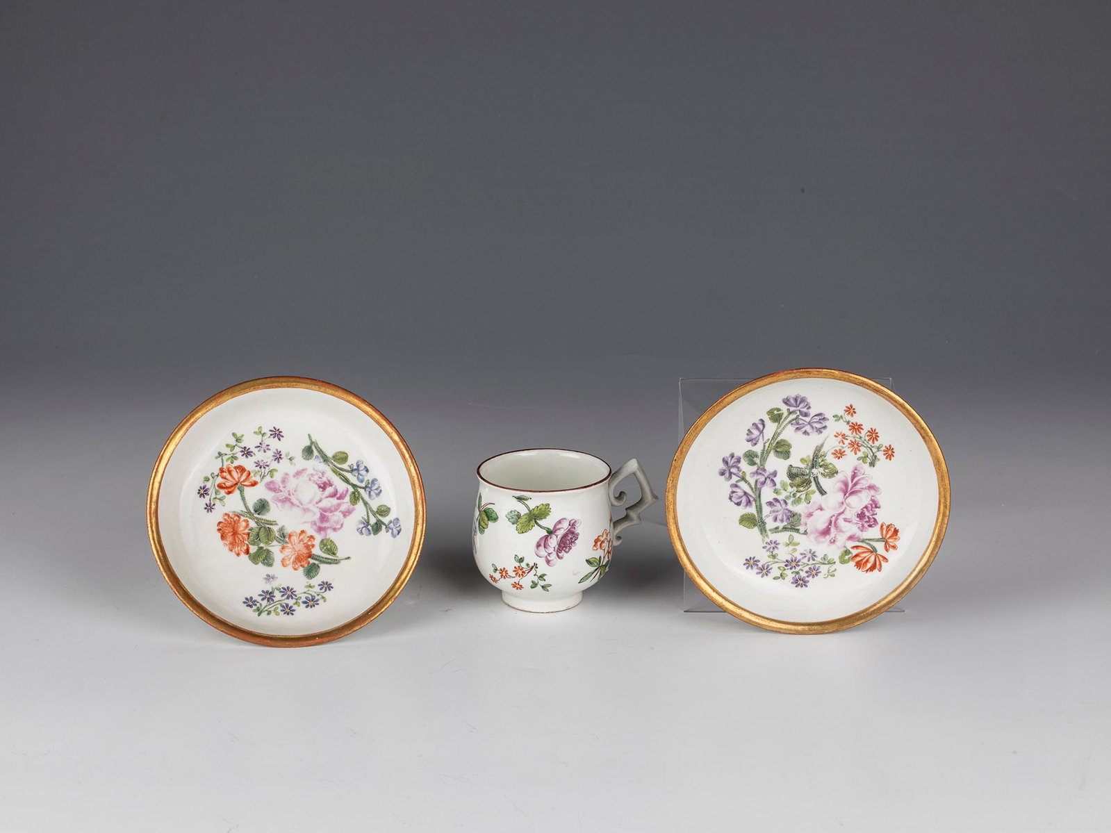 Cup and two saucers: Cup and two saucers Vienna, Du Paquier, c. 1730-35 Cup-shaped body on stand ring with side handle. Polychrome painted garden flowers with foliage all around the wall and in the mirror. The rim of the 