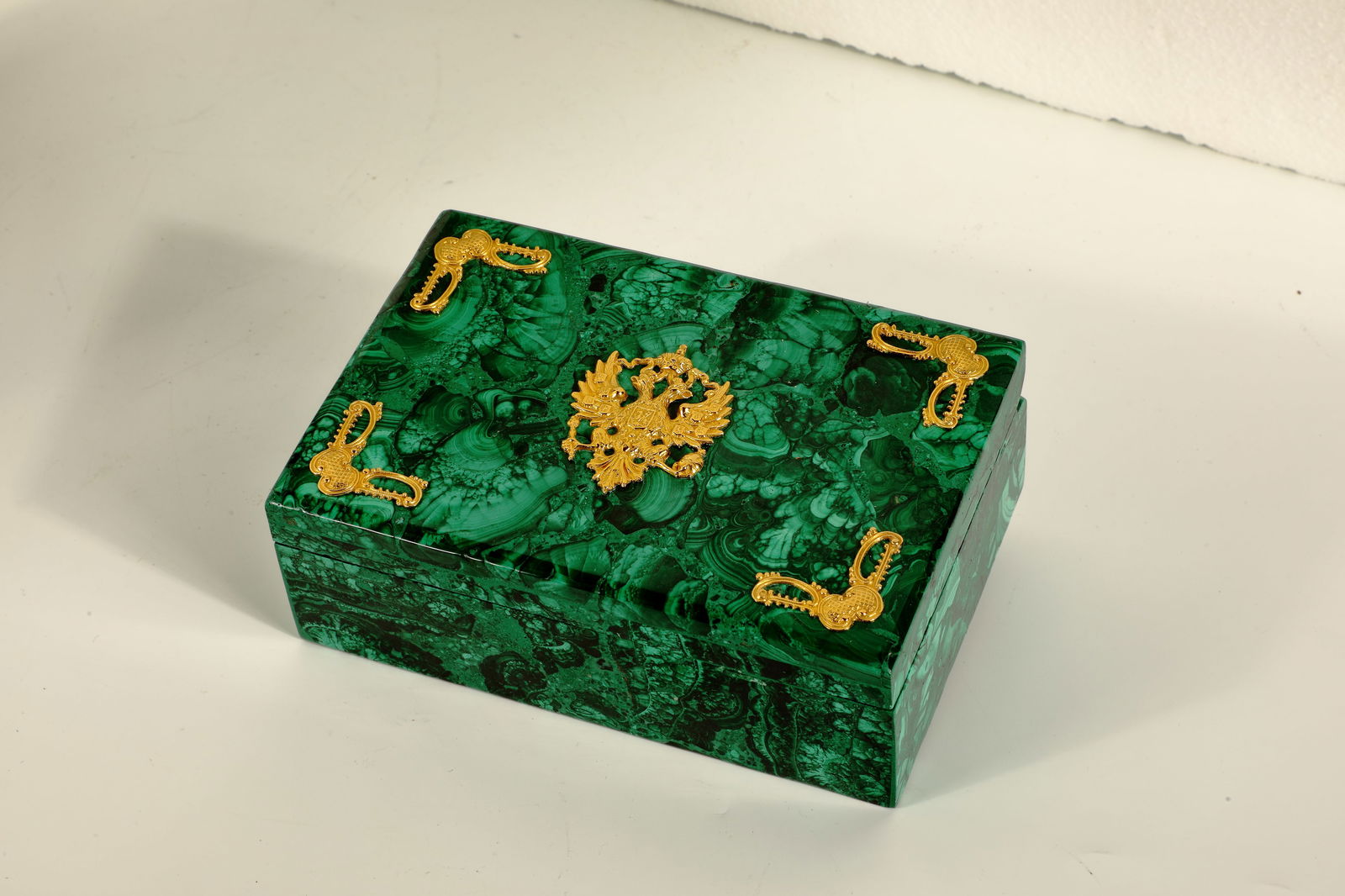 Malachite Decorative Box with Coat of Arms: Malachite Ornamental Box with Coat of Arms Ornamental box made of dark green malachite with a lively ''eyes'' veining. Hinged lid with bevelled corners and gilded silver inlay with the state coat of a