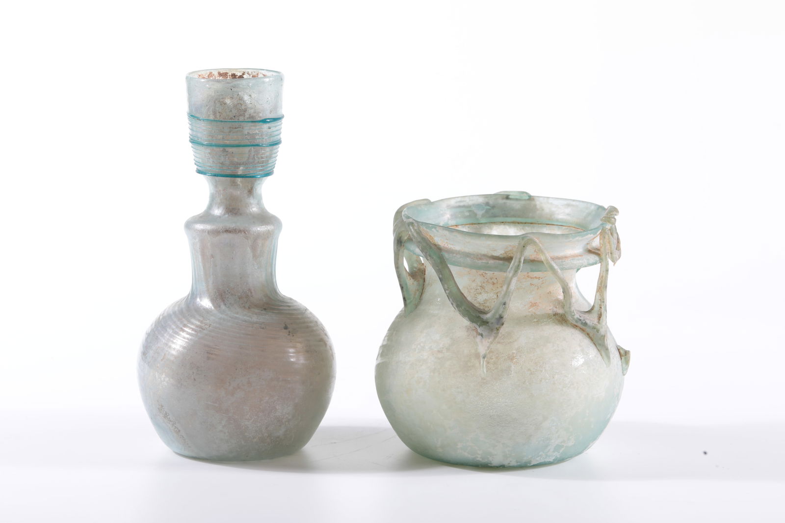 Mixed lot of two archaeological finds: Mixed lot of two archaeological finds Eastern Mediterranean, 4 - 5 centuries AD Consisting of: Bottle; green-blue, diagonally optically blown, iridescent glass. Spherical wall with a raised bottom.