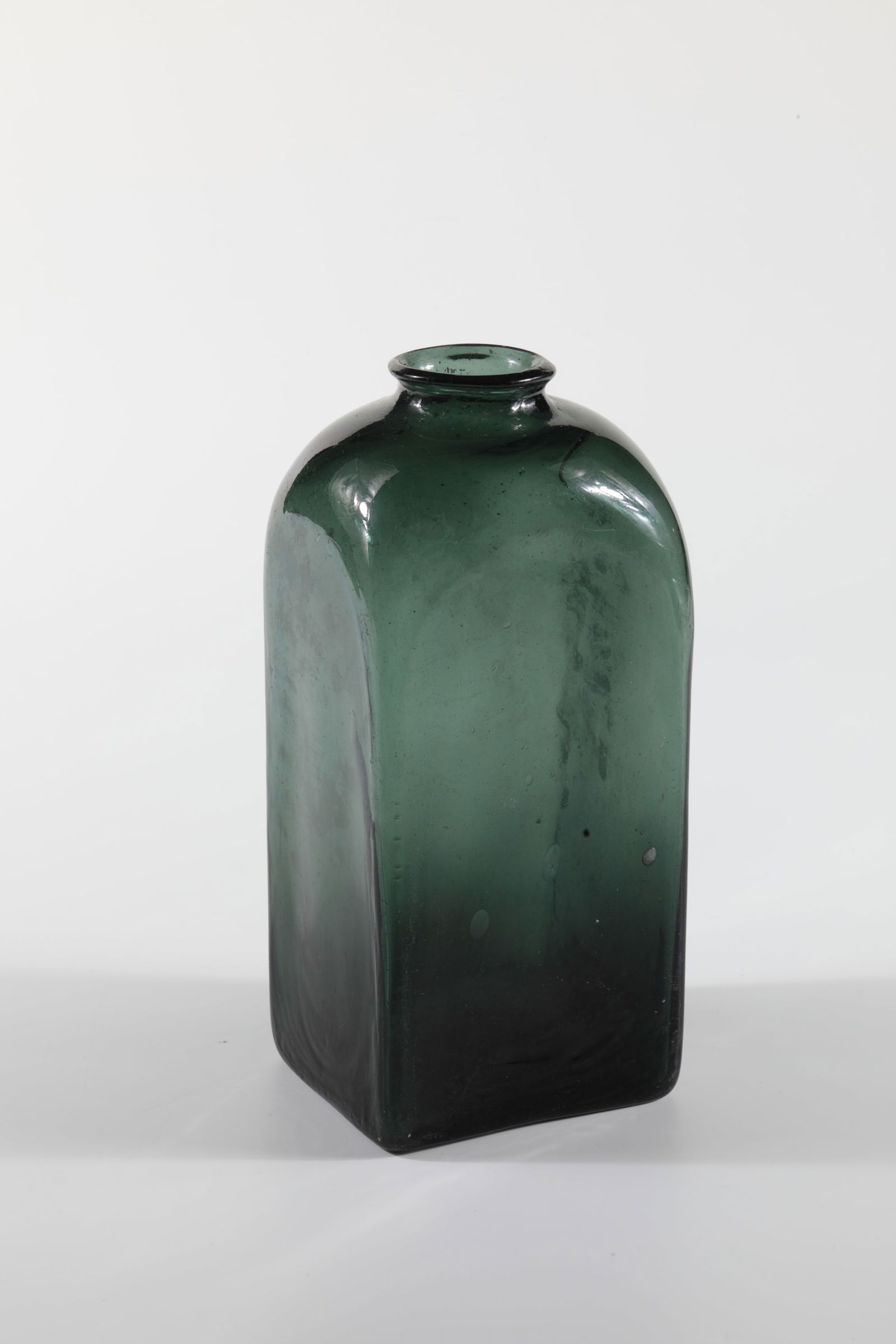 Square bottle: Square bottle Germany, 17th century. Dark green glass with slightly raised bottom and tear-off. Rectangular wall in cross-section with rounded shoulder and wide opening. H. 21,5