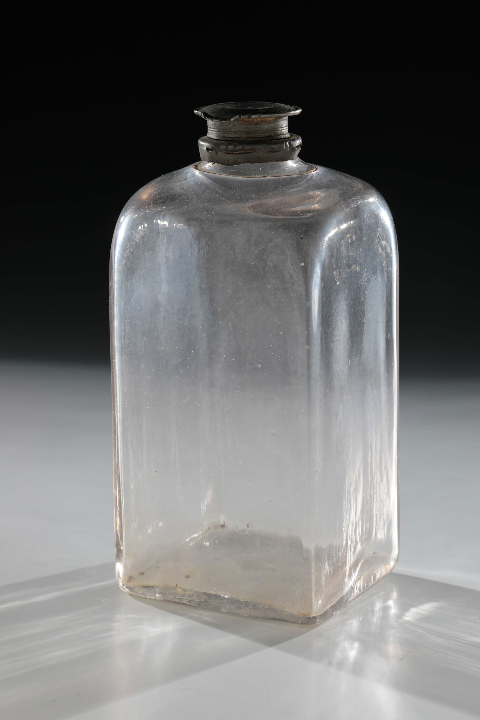 Square bottle with tin screw cap: Square bottle with tin screw cap Southern Germany, 18th century Colourless glass with tear-off. Rectangular wall in cross-section. H. 19.5 cm