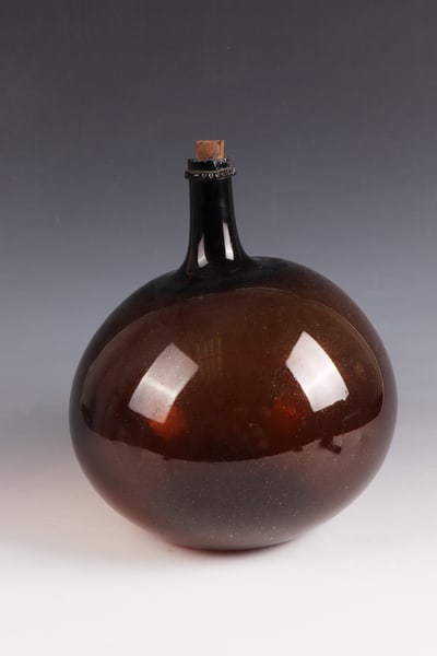 Onion bottle: Onion bottle France, probably Alsace, 18th century. Free-blown, brown glass. Bulbous wall. Tubular neck. Below the rim of the muzzle with a pipe tear-off, pinched glass thread placed all around. H.