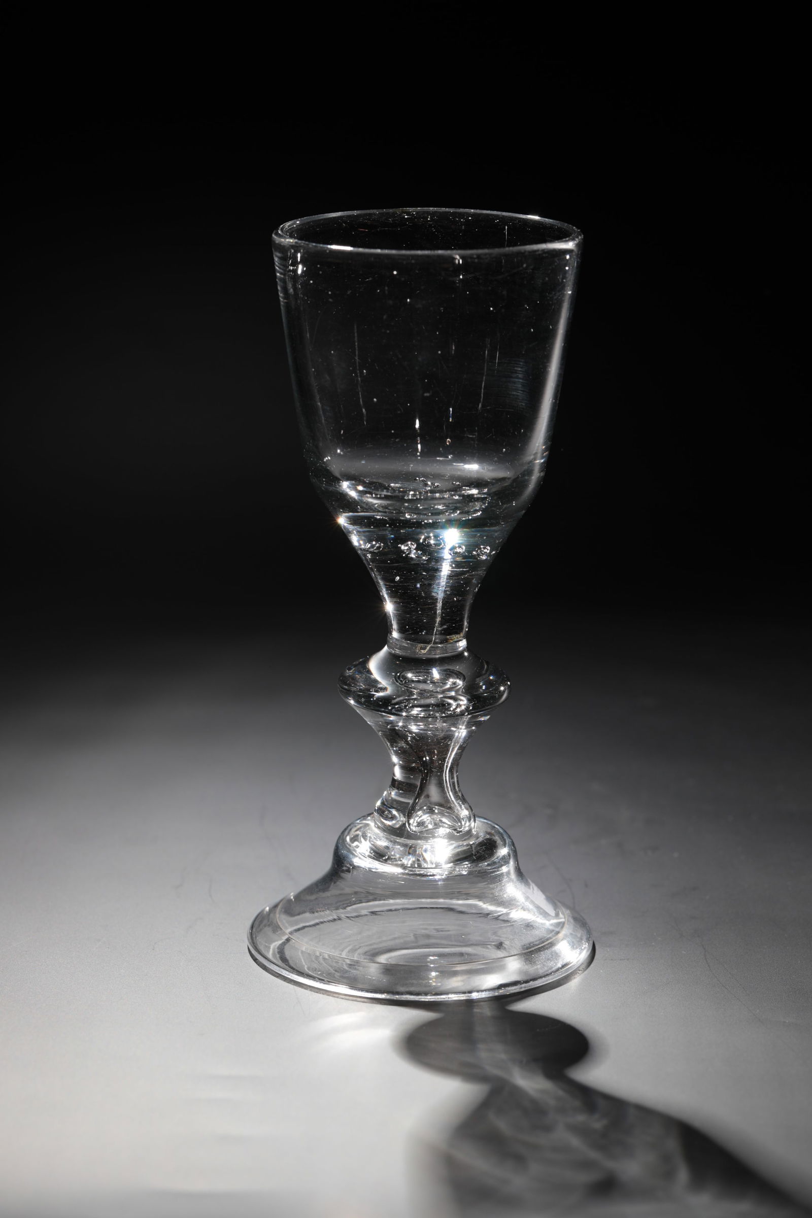 Goblet glass: Chalice glass Lauenstein, c. 1770 Bell-like foot with rim turned downwards and demolition. Compressed shaft with punctured air bladder. At the base of the kuppa, seven beads are pierced. H. 17 cm