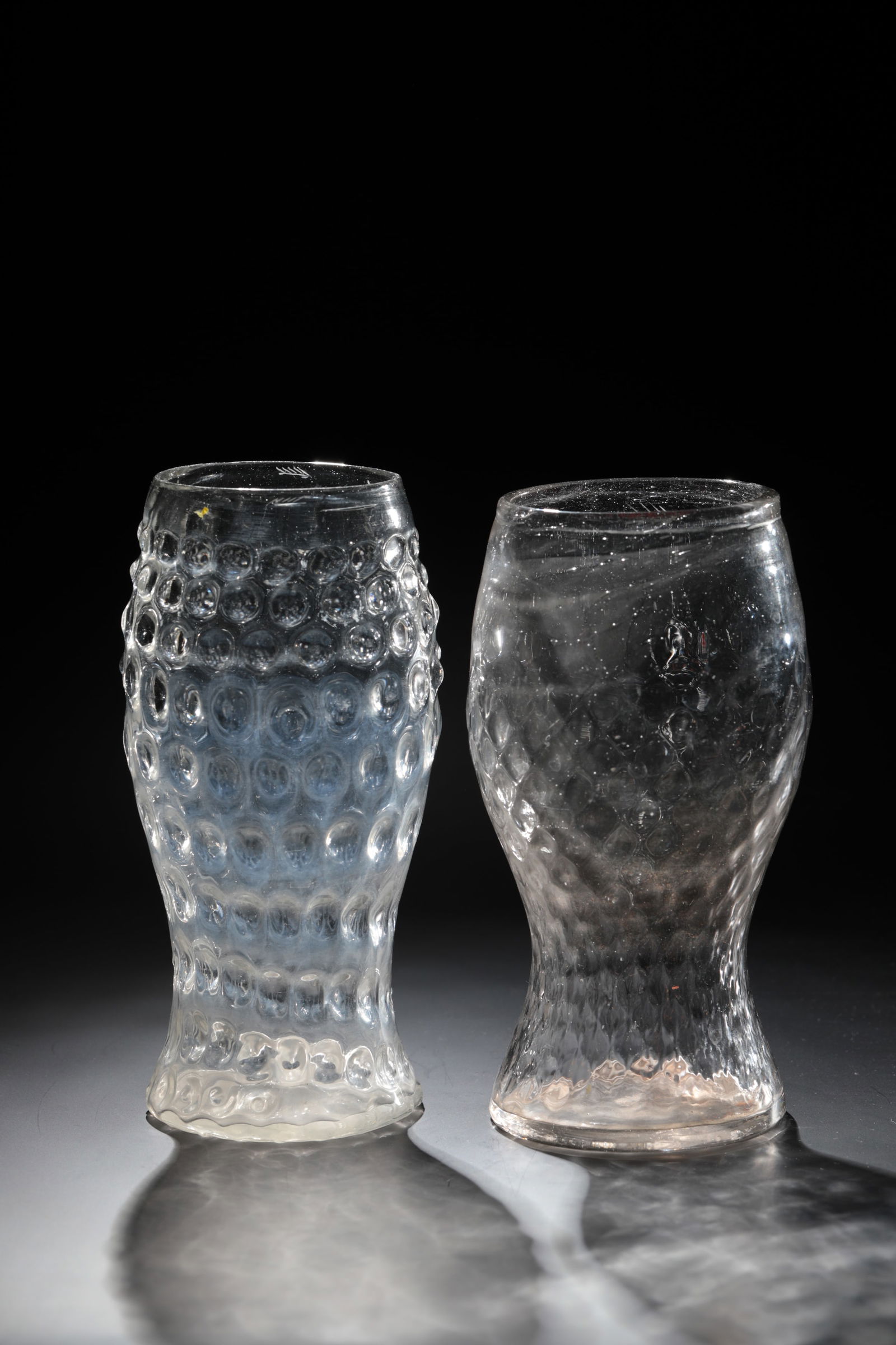 Two club cups: Two club cups Black Forest, 19th century. Glass blown into a model with optical wart or wedge decoration and sand tearing. H. 18.5 or 19.5 cm