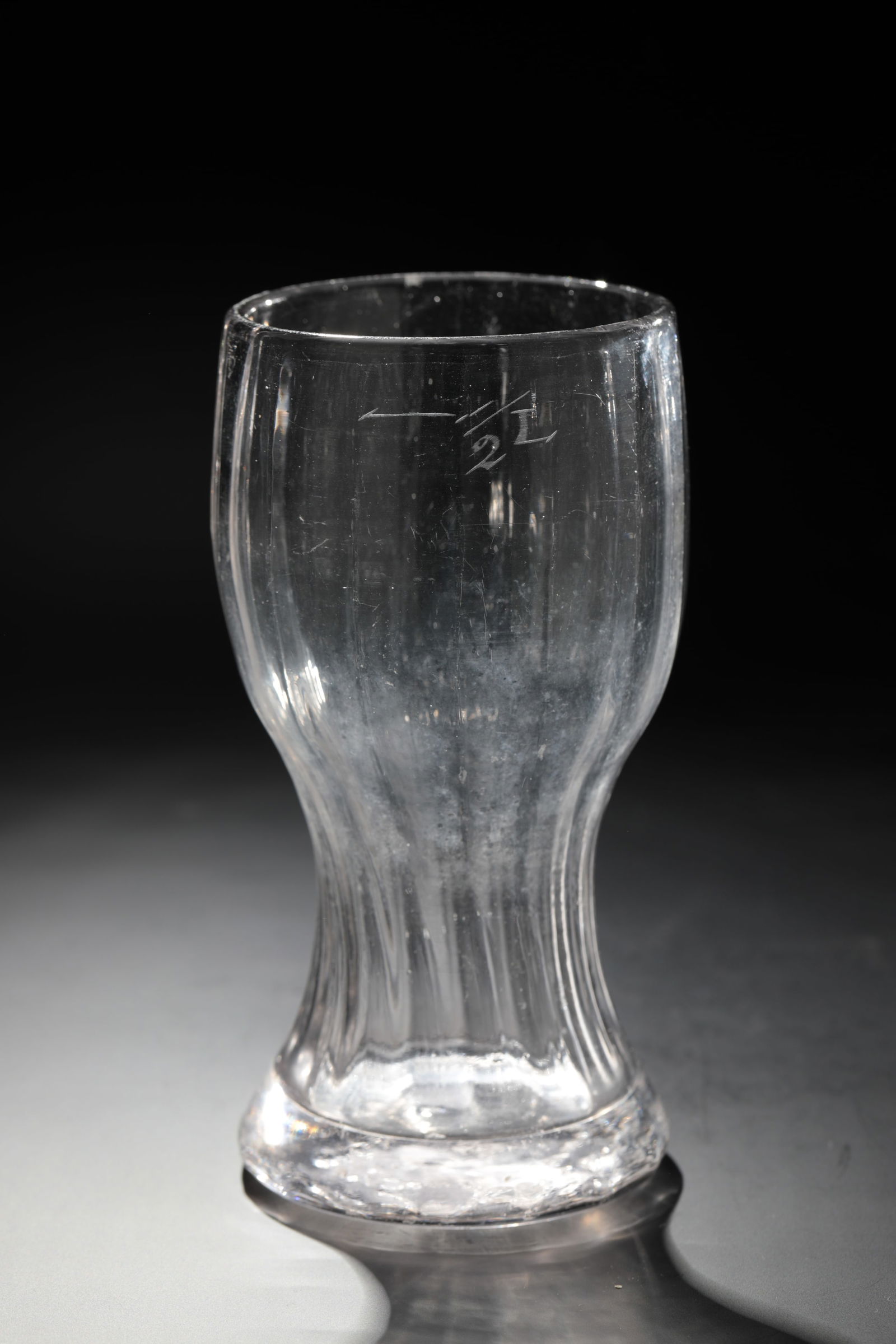 Club cup: Club cup, Germany, 19th century, colourless glass with tear-off. The club-shaped wall is ribbed lengthwise. Engraved calibration line ''1/2 L''. H. 17 cm